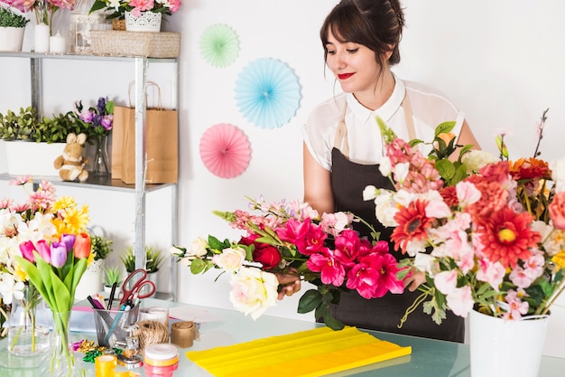 Weiblicher Florist, der Blumenblumenstrauß im Blumenshop macht