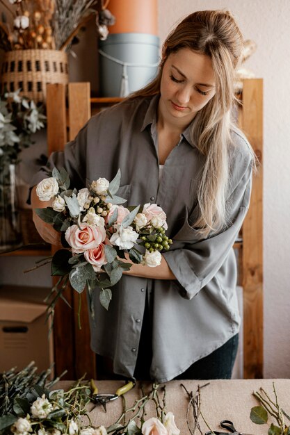 Weiblicher Florist, der ein schönes Blumenarrangement macht