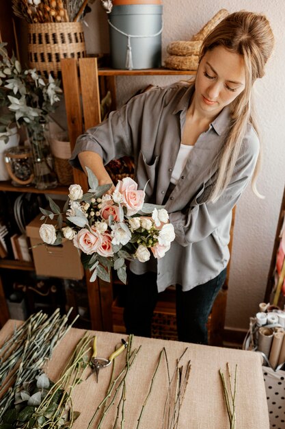 Weiblicher Florist, der ein schönes Blumenarrangement macht