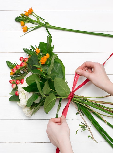 Kostenloses Foto weiblicher florist, der schönen blumenstrauß am blumenladen macht