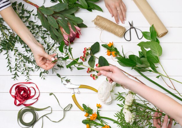 Weiblicher Florist, der schönen Blumenstrauß am Blumenladen macht