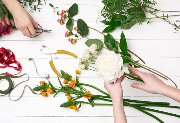 Weiblicher Florist, der schönen Blumenstrauß am Blumenladen macht