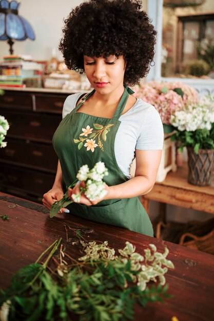 Weiblicher Florist mit Bündel weißen Blumen im Shop