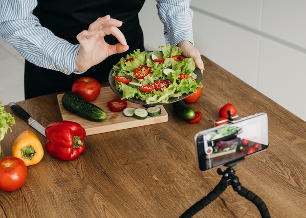 Weiblicher Lebensmittel-Blogger, der beim Kochen zu Hause strömt