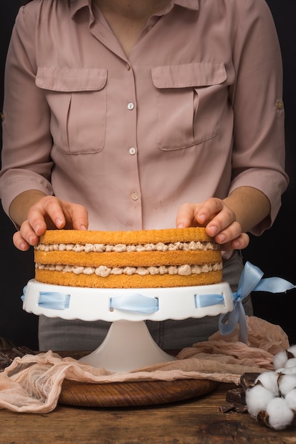 Kostenloses Foto weiblicher patissier, der kuchen zubereitet