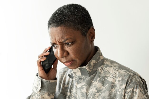 Weiblicher Soldat, der auf einer Smartphone-Kommunikationstechnologie spricht