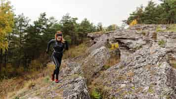 Kostenloses Foto weiblicher sportlicher jogger, der auf stein long shot läuft