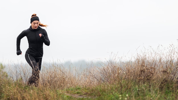 Weiblicher sportlicher Jogger, der draußen läuft