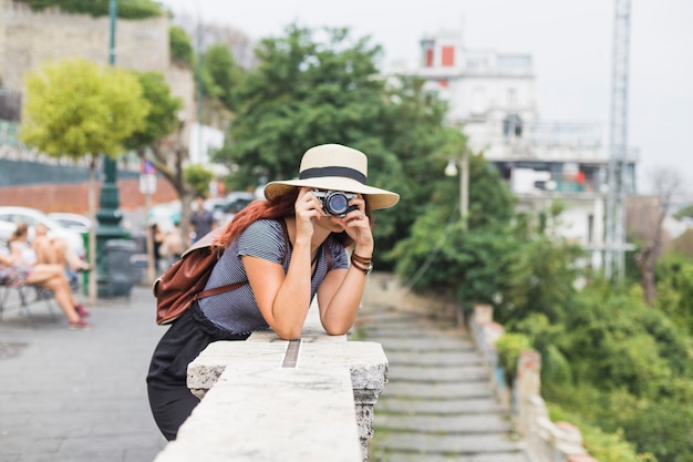 Weiblicher Tourist mit Kamera auf dem Balkon