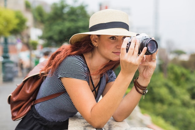 Weiblicher Tourist mit Kamera auf dem Balkon