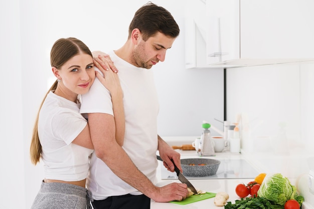 Weiblicher umarmender Freund beim Kochen