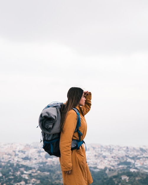 Kostenloses Foto weiblicher wanderer mit seinem rucksack, der ansicht betrachtet