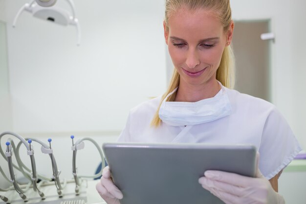 Weiblicher Zahnarzt, der eine digitale Tablette verwendet
