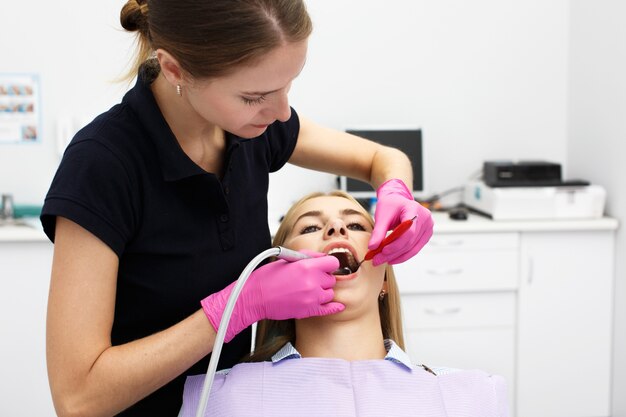 Weiblicher Zahnarzt, der ihre geduldigen Zähne behandelt