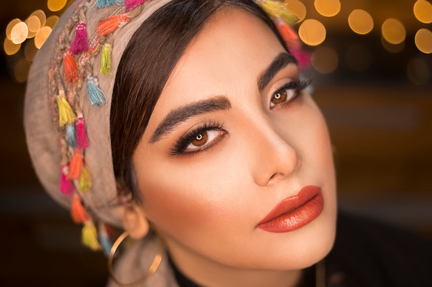 Weibliches Modell in ethnischer Art Kopfbedeckung mit romantischem Blick