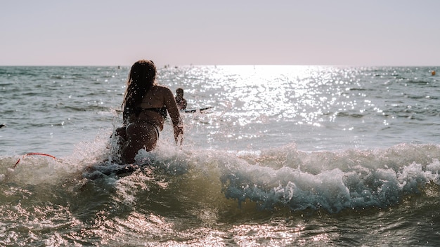 Weibliches Surfen auf kleinen Wellen