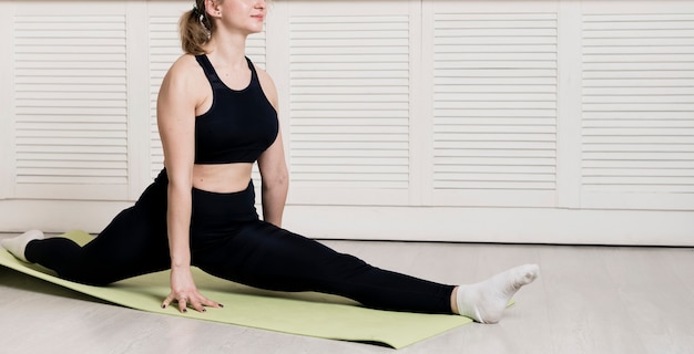 Kostenloses Foto weibliches training der nahaufnahme zu hause auf matte