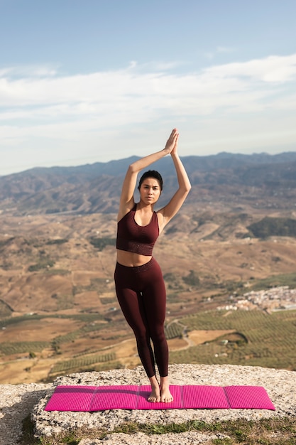 Kostenloses Foto weibliches übendes yoga der vorderansicht