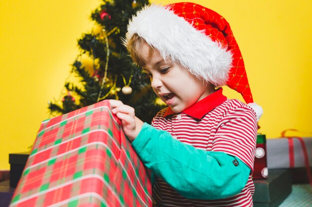 Weihnachten concepto mit jungenöffnungsgeschenk