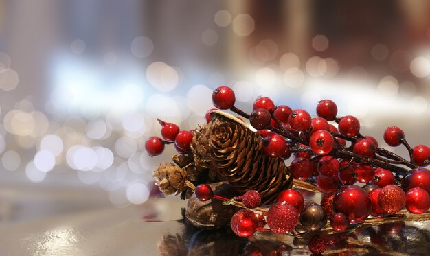 Weihnachten Hintergrund mit Beeren und Tannenzapfen gegen einen bokhe hellem Hintergrund