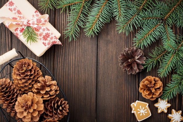 Weihnachten oder neujahr. tannenzweige, weihnachtsbaumspielzeug, sterne, schneeflocken und zapfen auf dunkelbraunem holz.