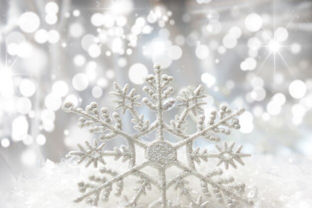 Weihnachten Schneeflocke im Schnee mit Bokeh Lichter eingebettet