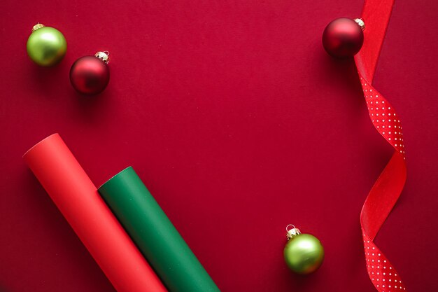 Weihnachts-flatlay- und urlaubsdesign-konzept-dekorationsverzierung und weihnachtsgeschenkverpackung auf rotem papier... Premium Fotos