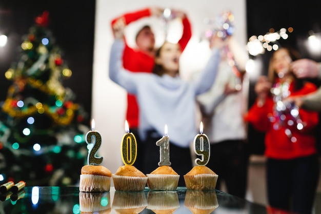 Weihnachts- und Neujahrsvorbereitungen. Firma von attraktiven glücklichen jungen Leuten feiert