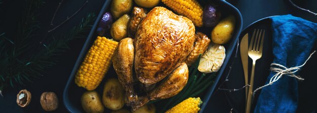 Weihnachtsabendessentisch mit Huhn auf Dunkelheit