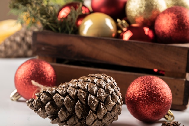 Weihnachtsbälle und -kegel in der Holzkiste und auf dem Tisch.