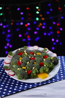 Weihnachtsbaum aus brokkoli auf dem tisch auf dunklem hintergrund