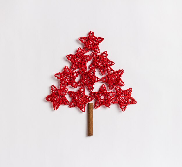 Weihnachtsbaum gemacht vom Konzept der roten Sterne lokalisiert auf weißem Hintergrund