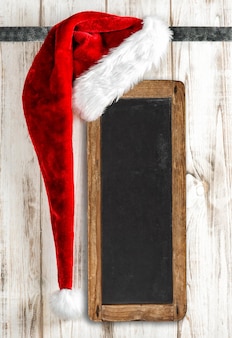 Weihnachtsdekoration weihnachtsmütze und vintage-tafel-banner-zeichen