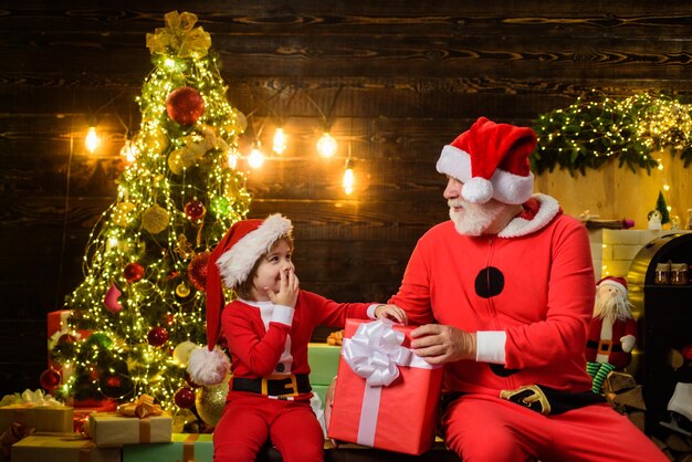 Weihnachtsdekoration weihnachtszeit weihnachtsgeschenk lächelnder kleiner kinderjunge im sankt-kostüm mit