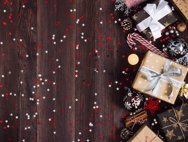 Kostenloses Foto weihnachtsferiengeschenkbox auf verzierter festlicher tabelle mit kiefernkegel-zuckerstangenkerzenball