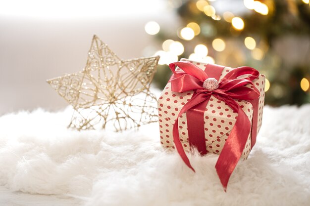 Weihnachtsgeschenk auf dekorativem Sternhintergrund auf unscharfem bokeh Hintergrund schließen oben.