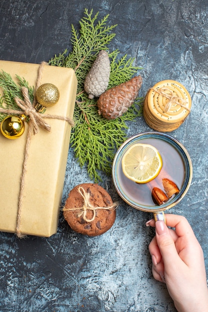 Weihnachtsgeschenk von oben mit süßen Keksen und einer Tasse Tee auf hell-dunklem Hintergrund