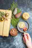 Kostenloses Foto weihnachtsgeschenk von oben mit süßen keksen und einer tasse tee auf hell-dunklem hintergrund