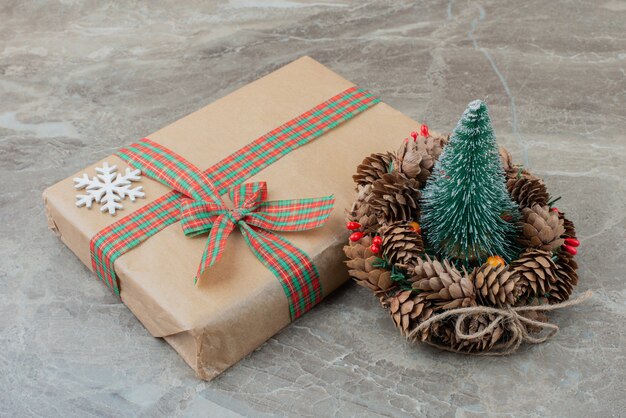 Weihnachtsgeschenkbox, Kiefer und Kranz auf Marmor.