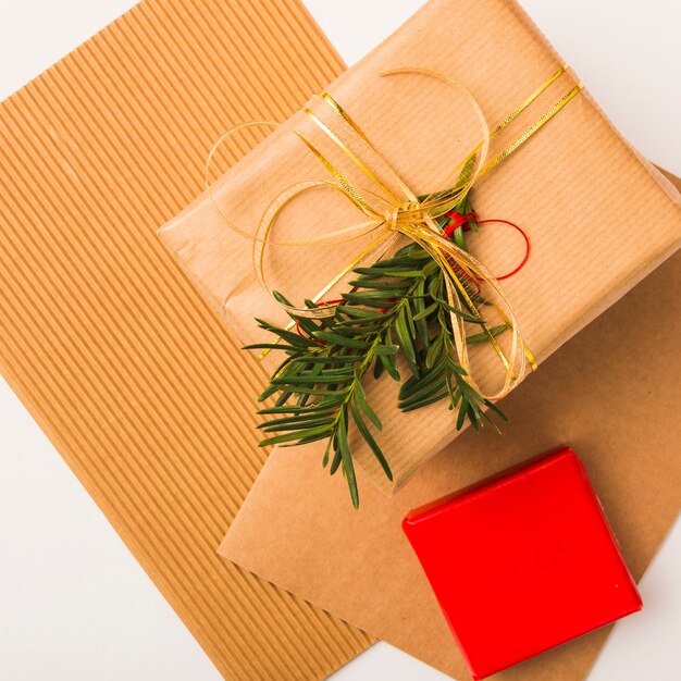 Weihnachtsgeschenkbox mit goldenem Band und Tannenzweig