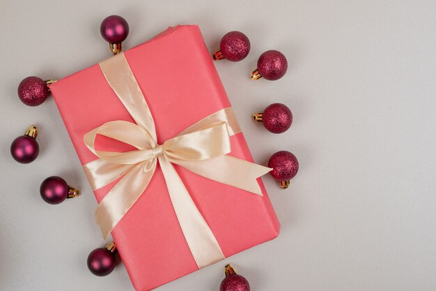 Weihnachtsgeschenkbox mit kleinen roten Kugeln auf weißer Oberfläche