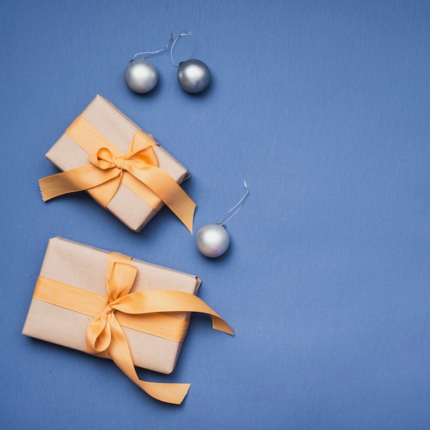 Weihnachtsgeschenke mit silbernen Kugeln auf blauem Hintergrund