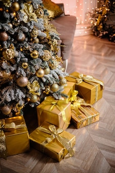 Weihnachtsgeschenke unter dem weihnachtsbaum. silvester und weihnachten. verpacktes geschenk. schöne verpackung. band und schleife auf der verpackung.