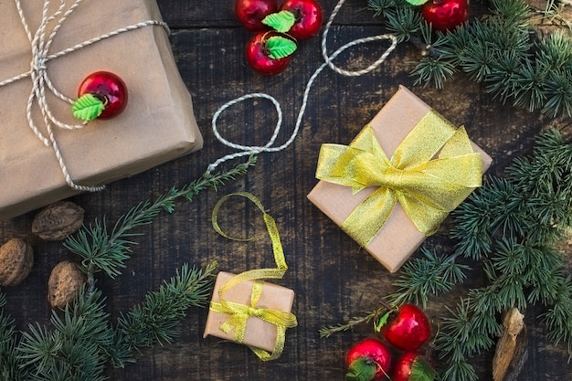 Weihnachtsgeschenke unter Nadelbaumniederlassungen und -äpfeln