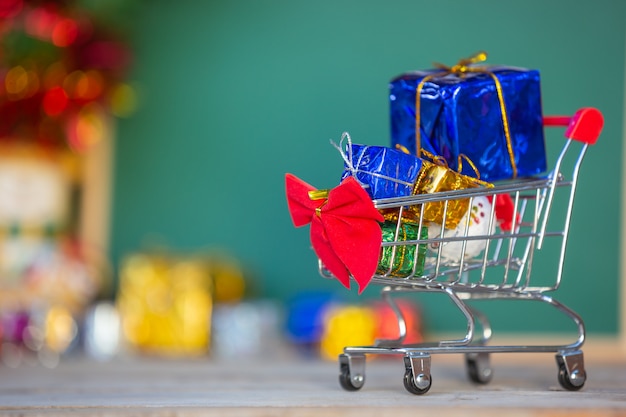 Weihnachtsgeschenkkästen in den verschiedenen farben gelegt in einen einkaufswagen