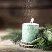 Kostenloses Foto weihnachtsgrüne kerze mit tannenzweigen und zapfen auf holztisch