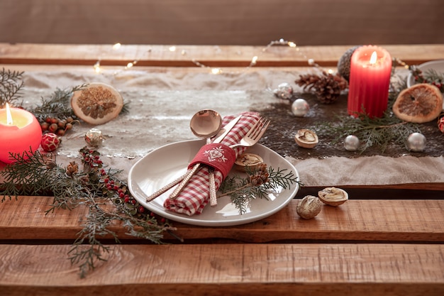 Weihnachtshintergrund mit Besteck und einem Teller auf dem festlich gedeckten Tisch, Kopienraum.