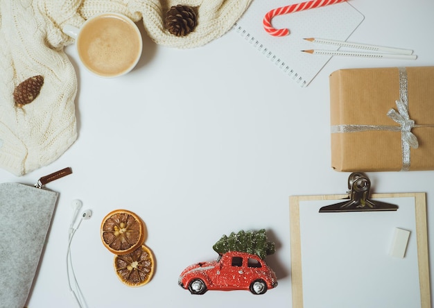 Weihnachtshintergrund mit Kaffeespielzeug und Geschenken auf weißem Tisch Draufsicht flach gelegt