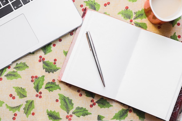 Weihnachtshintergrund mit Laptop und offenem Buch