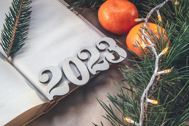 Kostenloses Foto weihnachtshintergrund mit zahlen 2023 zwischen mandarinen und fichtenzweigen